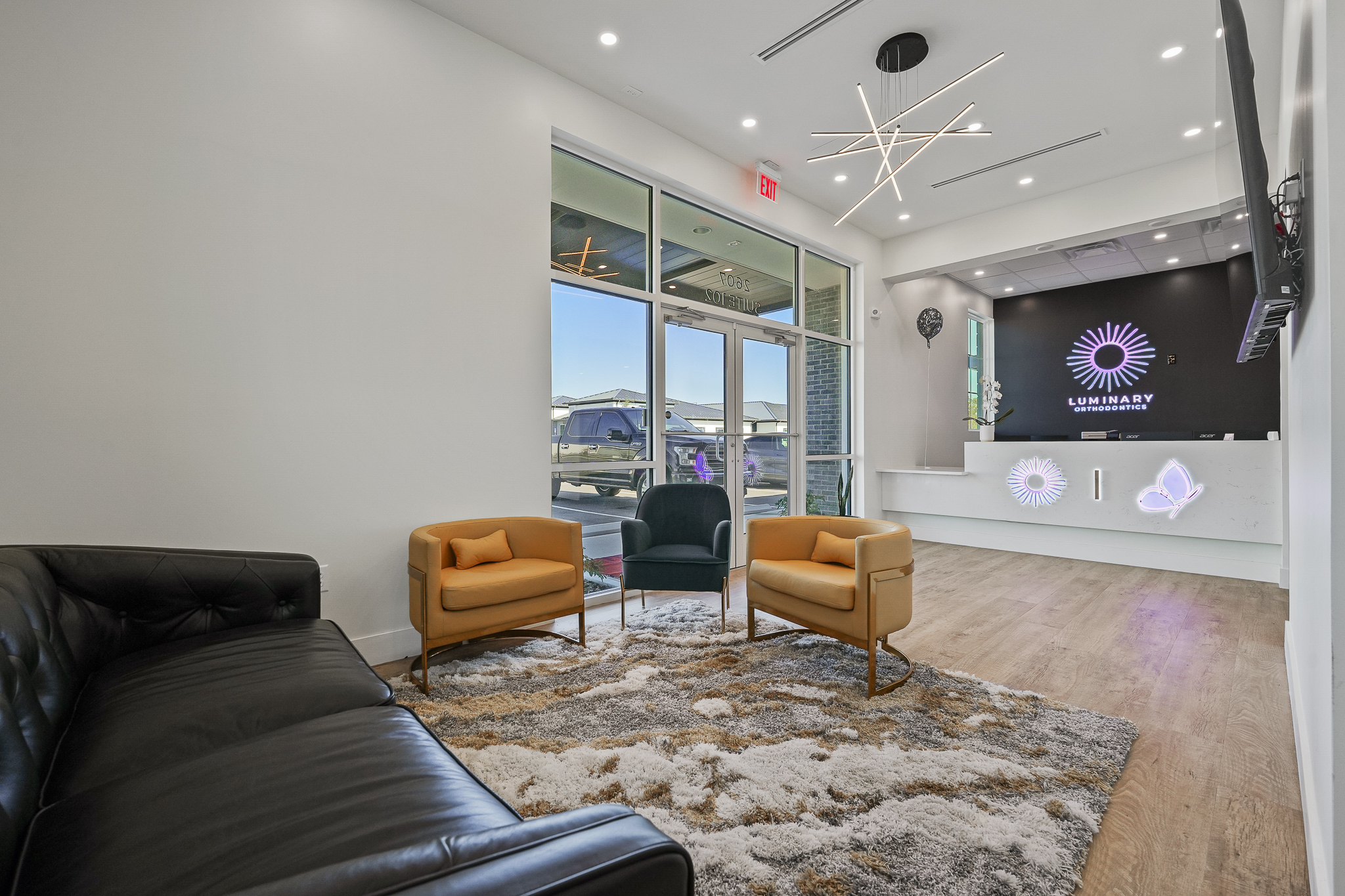 Modern reception desk at Luminary Orthodontics with illuminated logo in Clermont" Title: "Reception Desk